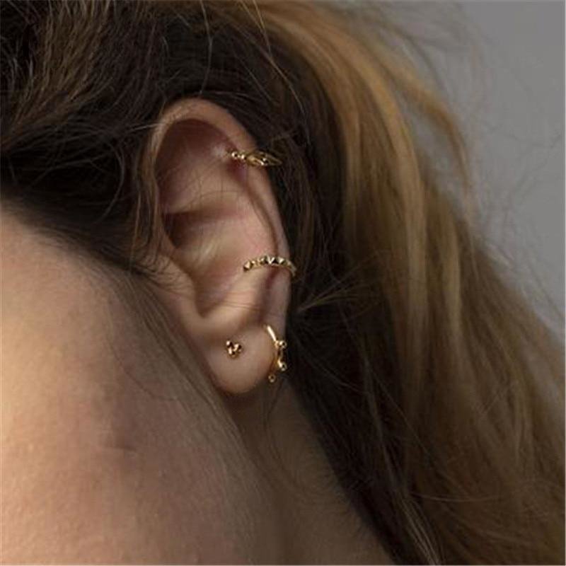 A model wearing gold alternative earrings.