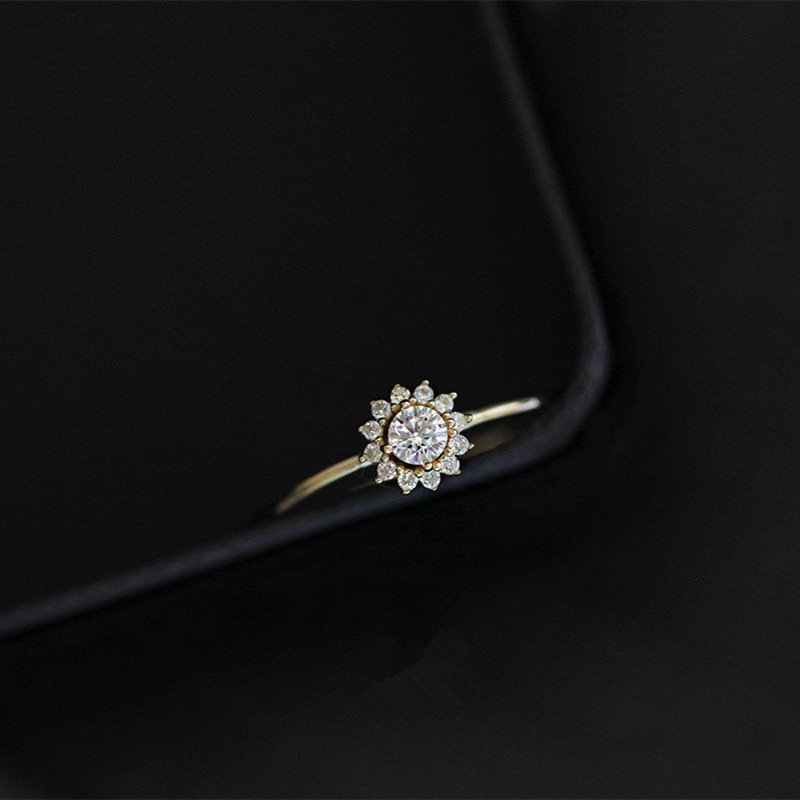 Gold CZ solitaire ring on black background.