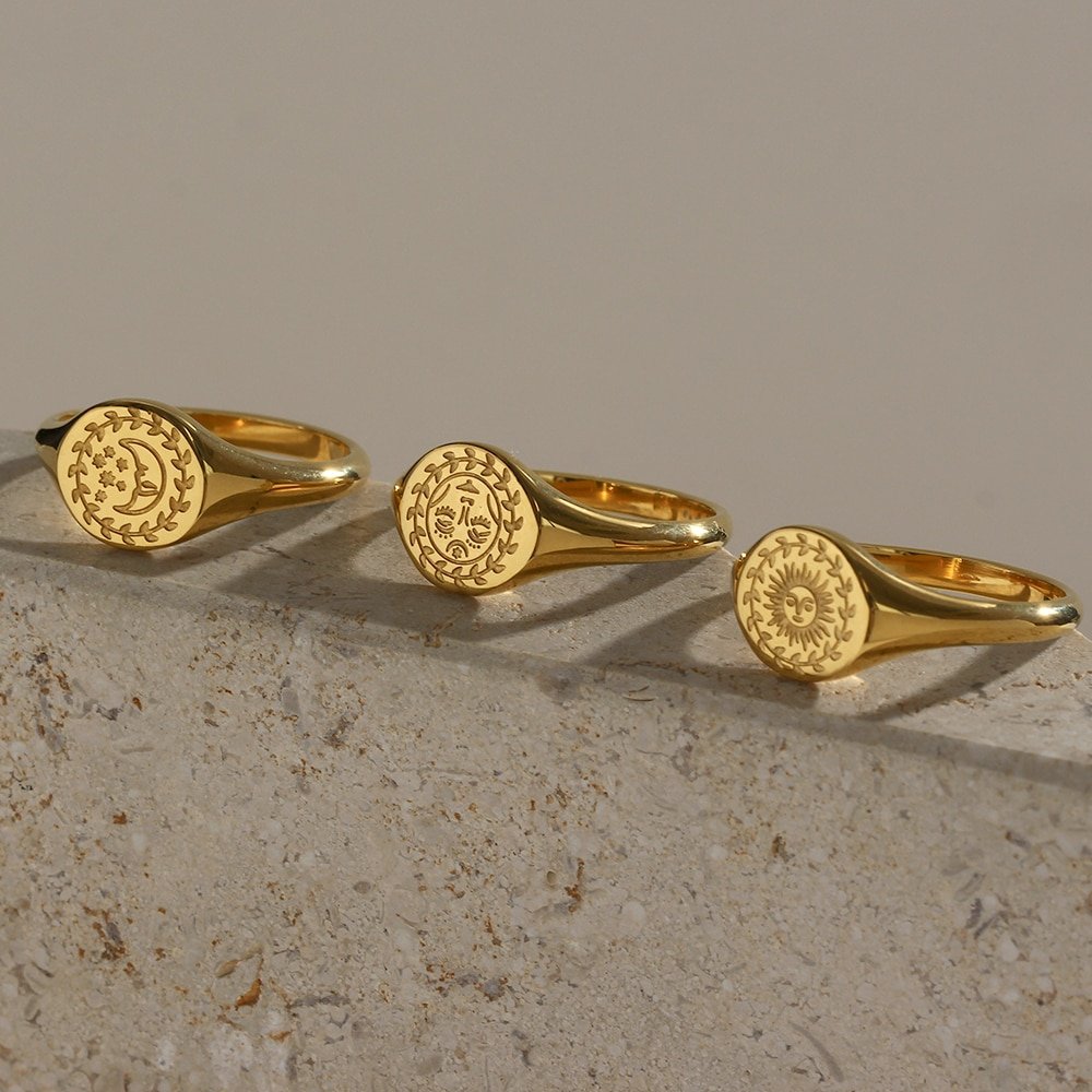 Three gold signet rings with celestial engravings.