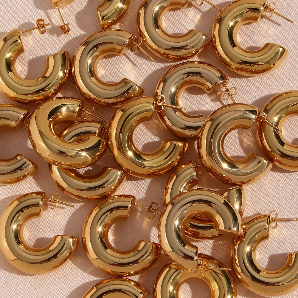Multiple gold chunky hoop earrings.