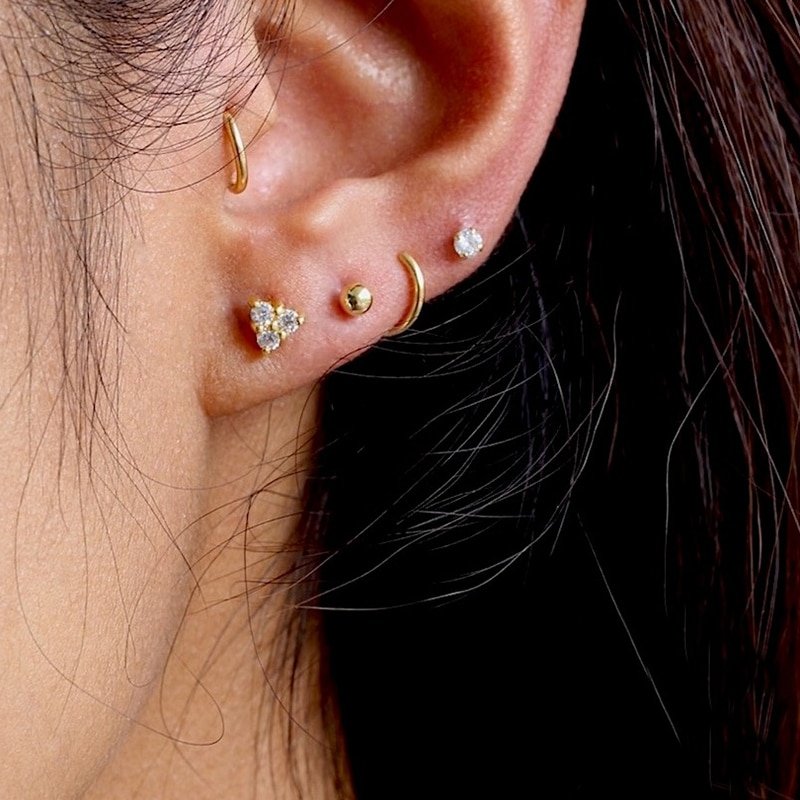 A model wearing multiple ear piercings.