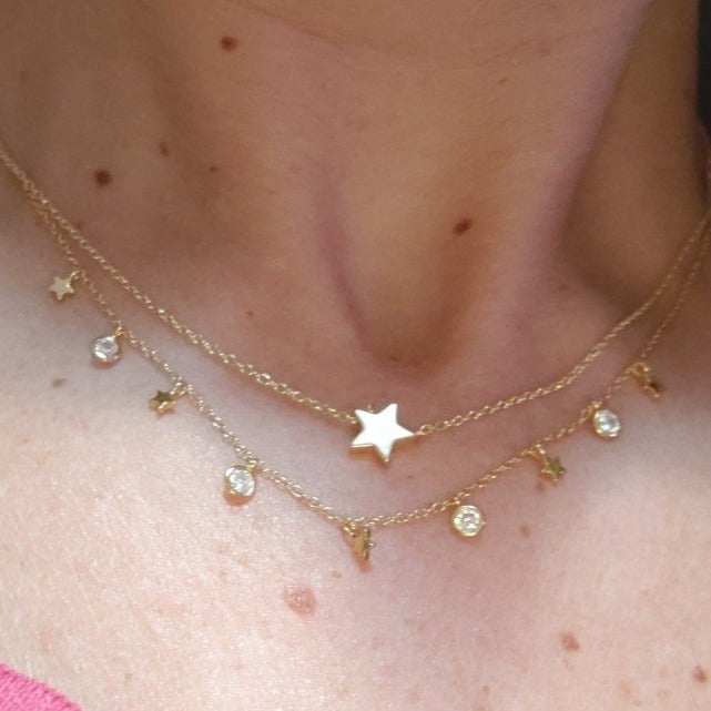 A woman wearing the gold Tiny Star Necklace.
