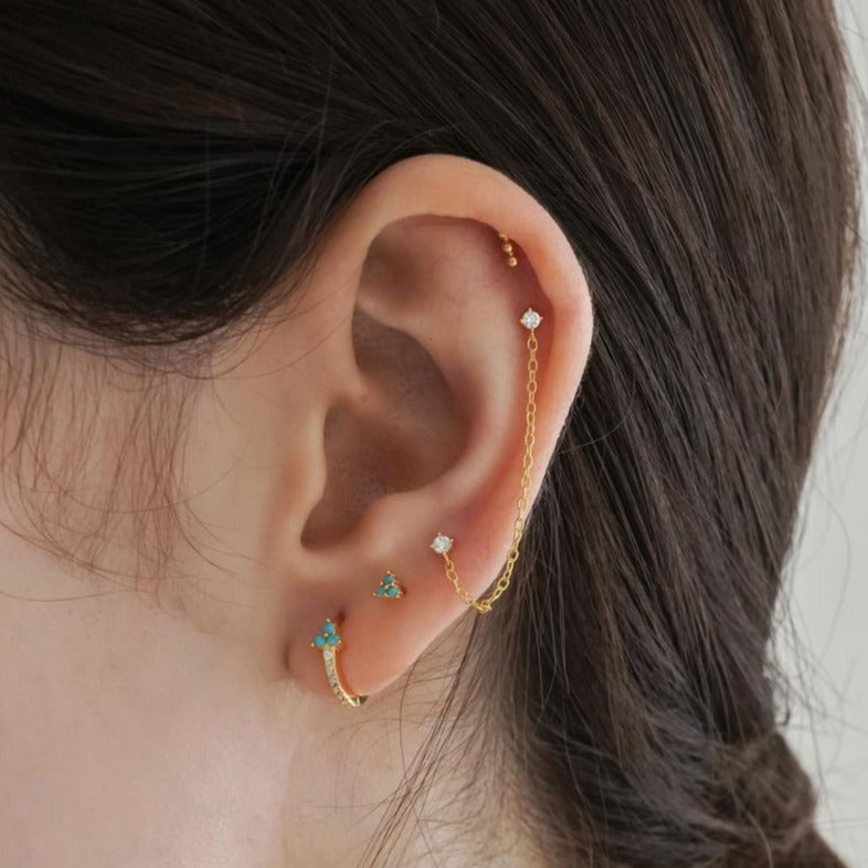 A model wearing tiny Turquoise Trinity Studs.