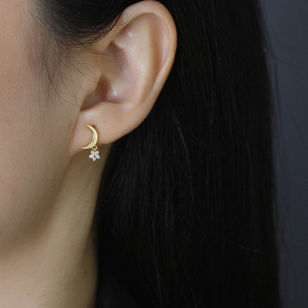 Amodel wearing the gold Twinkling Moon Earrings.