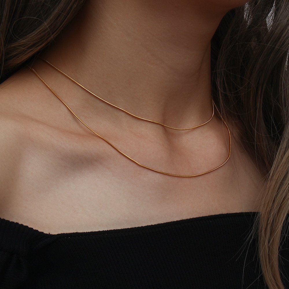 A model wearing two different lengths of the gold snake chain necklace.