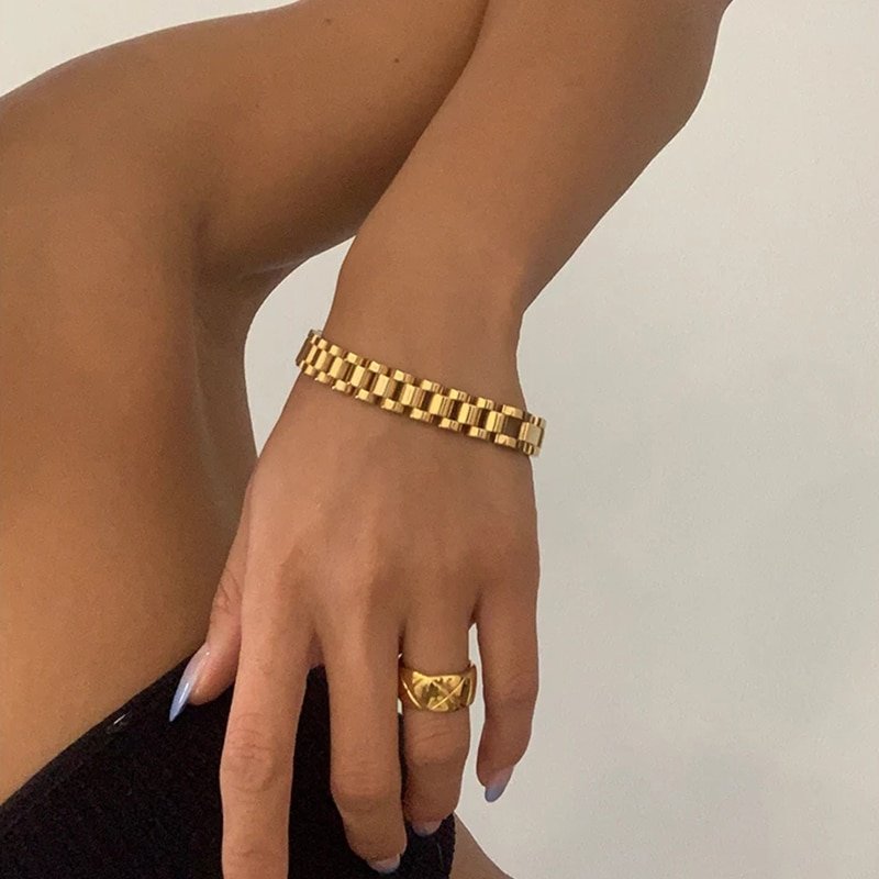 A model wearing a gold bracelet and ring.