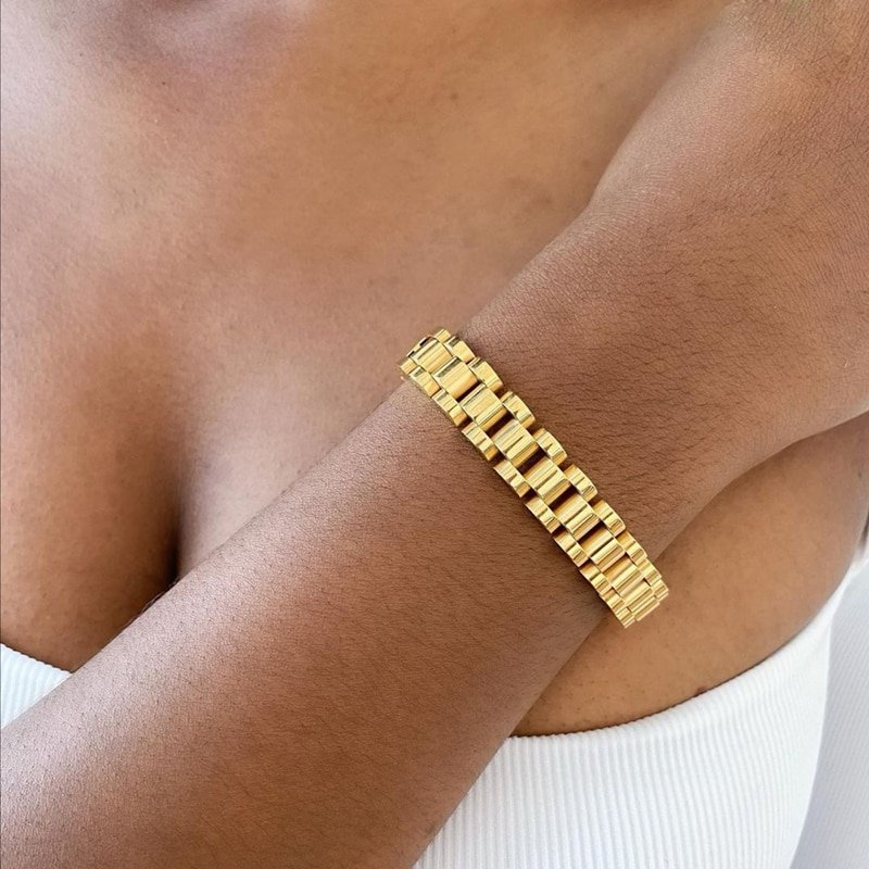 A woman wearing the gold Watch Band Bracelet.