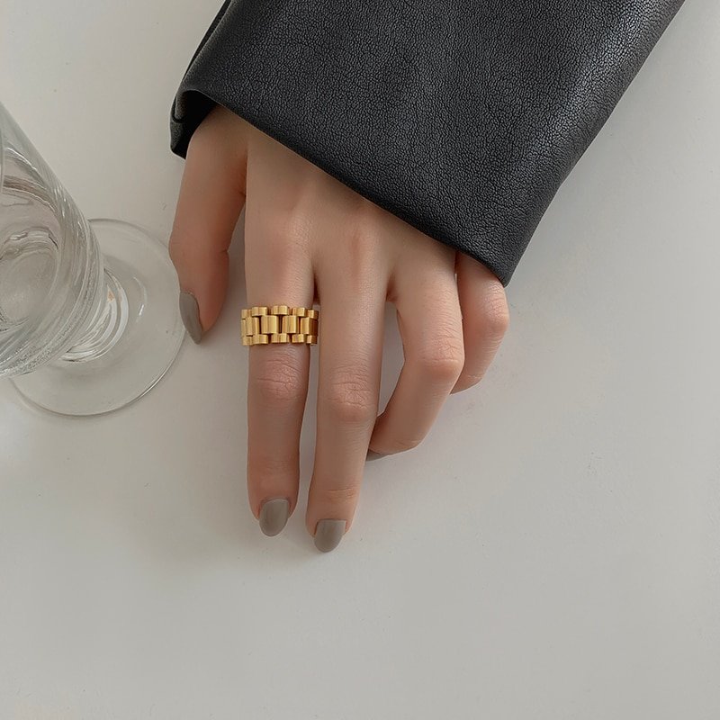 A model wearing a gold watch link ring band.