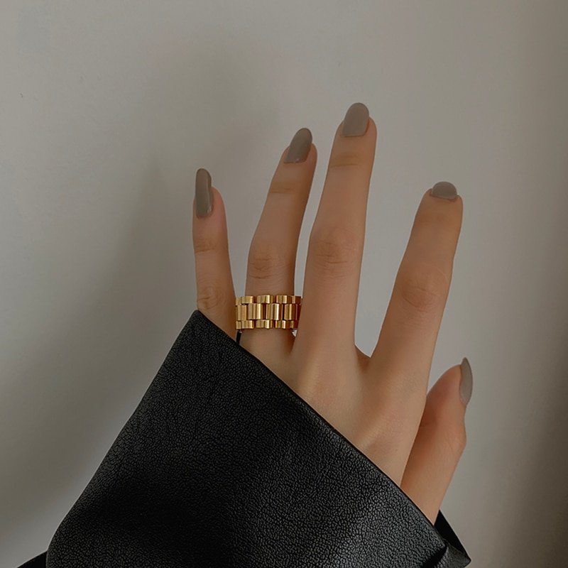 A woman wearing a think watch link ring.