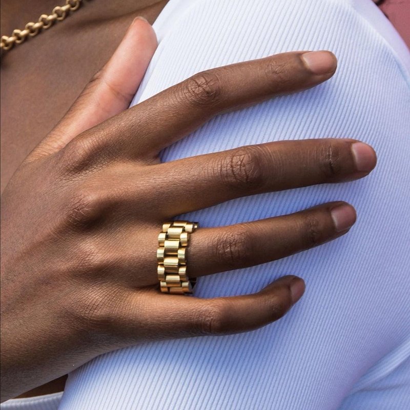 A model wearing a chunky gold ring band.