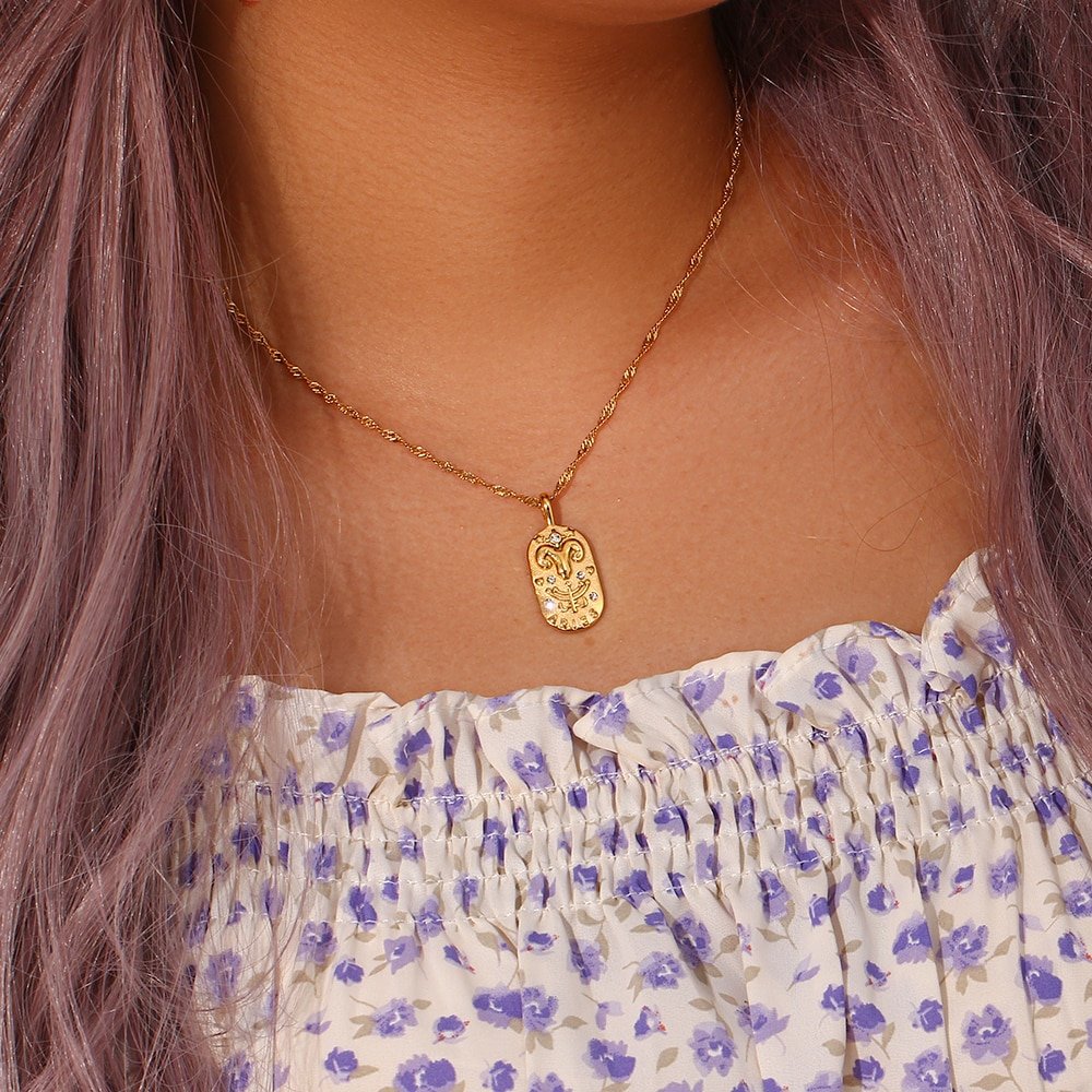 A model wearing a Zodiac Amulet Gold Necklace.