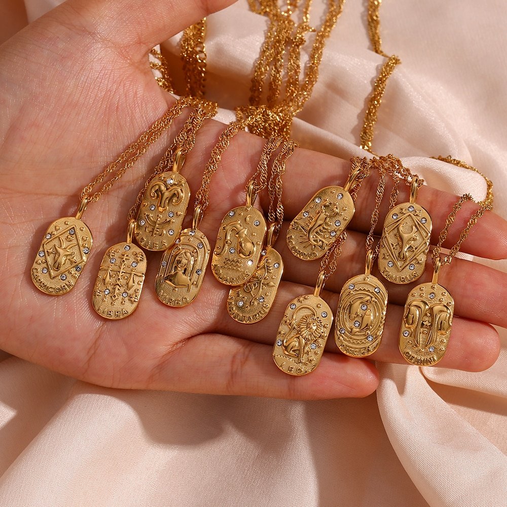 A woman holding tweleve Zodiac Amulet Gold Necklaces in her hand.