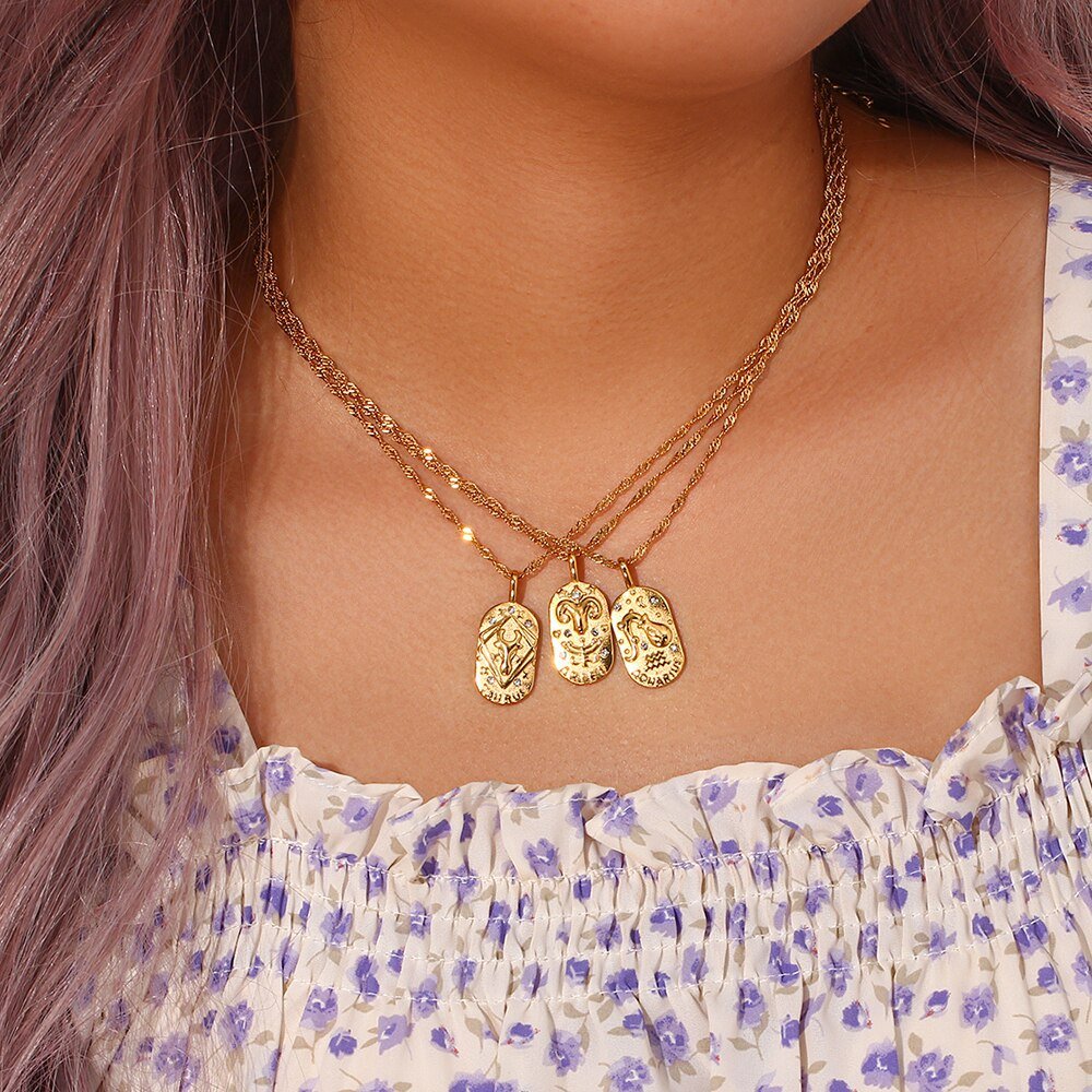 A woman wearing three Zodiac Amulet Gold Necklaces.