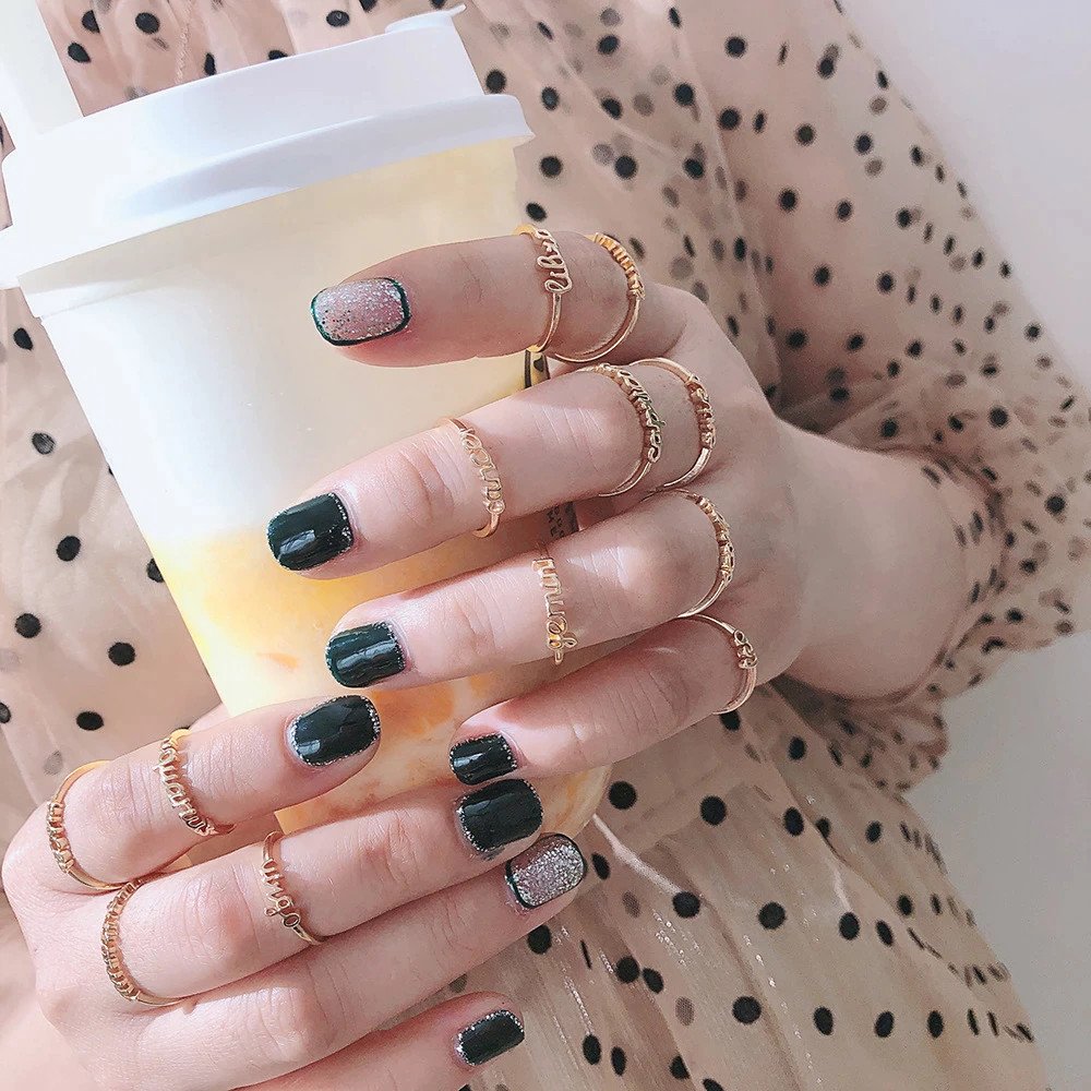 A woman wearing multiple Zodiac Name Rings.