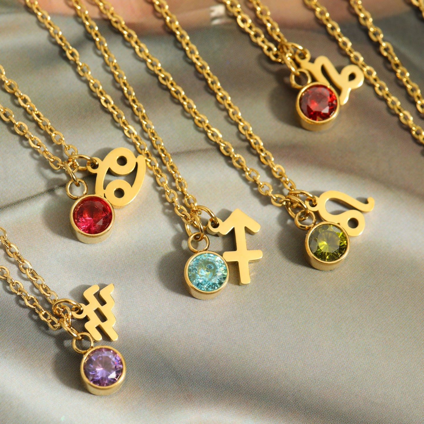 Multiple gold Zodiac necklaces.